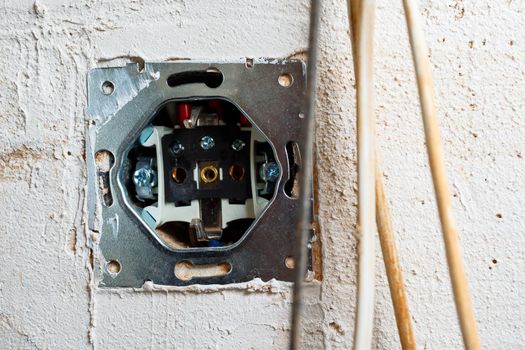 Sockets when mounted without a cover. During repair. open the wires. European nest without cover isolated on a white background. Professional installation of electrical outlets