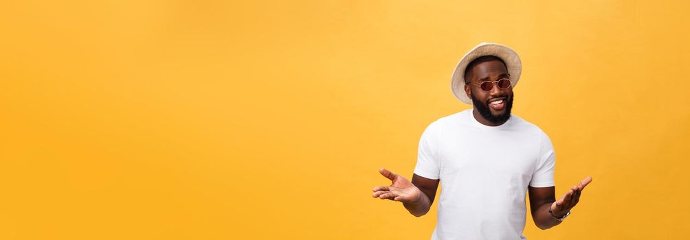 Portrait of handsome young african guy smiling in white t-shirt on yellow background.