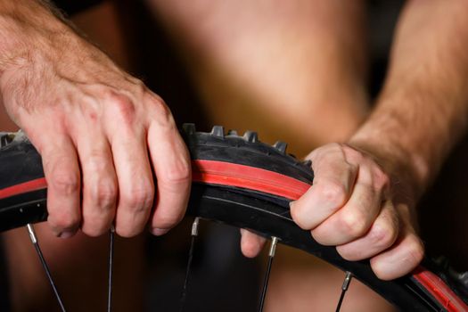 A man changes the camera on a bicycle wheel. Spike Bike Chamber