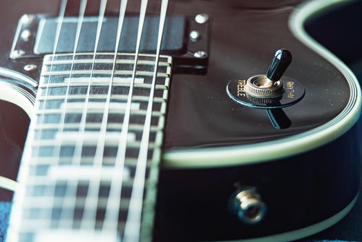 Detail of six-string electric guitar closeup, selective focus. vintage style.