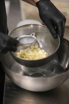 chef making for icing a lilac drip cake in the professional kitchen lab
