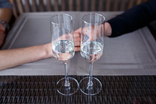 Served table in a restaurant for two. Blue plates for food, two glasses. Romantic evening concept