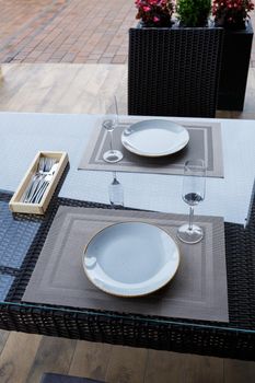 Served table in a restaurant for two. Blue plates for food, two glasses. Romantic evening concept