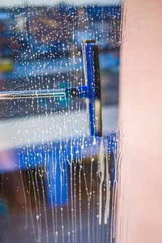 Window cleaning brush. Large window in a multi-storey building, cleaning service. Window cleaning in high-rise buildings, houses with a brush. Dust removal and glass washing.