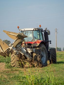 farmer with tractor plowing the land in the countryside.