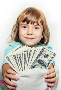 The child is holding money in his hands. Selective focus.