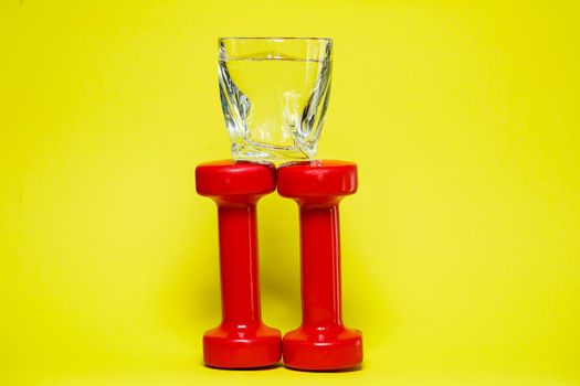 red dumbbells, a glass of water, colored background, sports, energy drink, equipment for the gym