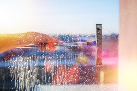 Window cleaning brush. Large window in a multi-storey building, cleaning service. Window cleaning in high-rise buildings, houses with a brush. Dust removal and glass washing.