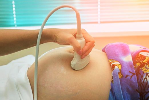 Cropped close up of a pregnant woman having ultrasound scanning at the medical clinic copyspace equipment technology modern pregnancy medicine people