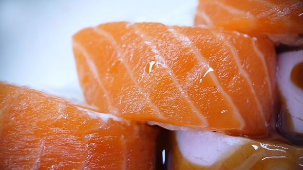 Texture or background .Sushi rolls of red fish and ham on a light background.Top view.Macrophotography