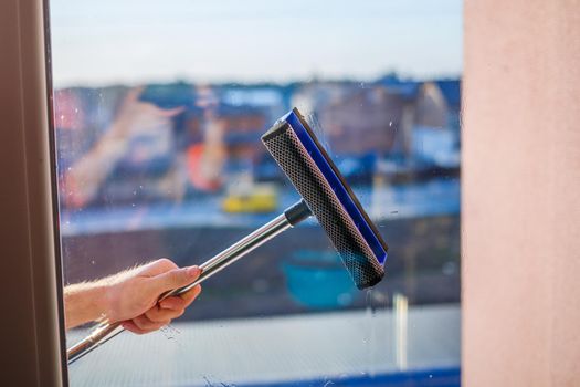 Window cleaning in high-rise buildings, houses with a brush. Window cleaning brush. Large window in a multi-storey building, cleaning service. Dust removal and glass washing.