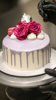 chef usign macaron , flowers and text sign for a celebration cake