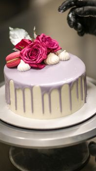 chef usign macaron , flowers and text sign for a celebration cake