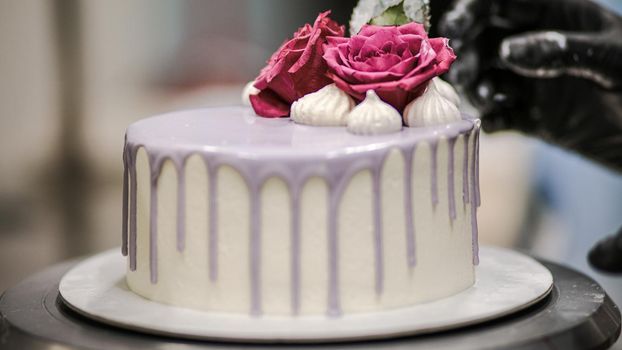 chef usign macaron , flowers and text sign for a celebration cake