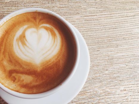 Morning drink, breakfast and rustic style concept - Cup of hot cappuccino in a cafeteria, coffee on a wooden table in cafe