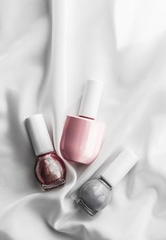 Cosmetic branding, salon and glamour concept - Nail polish bottles on silk background, french manicure products and nailpolish make-up cosmetics for luxury beauty brand and holiday flatlay art design