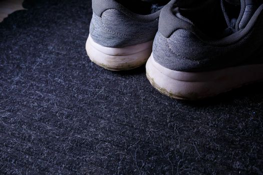 Gray men's sneakers with a dirty sole from the earth and grass, shoes for jogging and sports