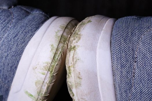 Gray men's sneakers with a dirty sole from the earth and grass, shoes for jogging and sports