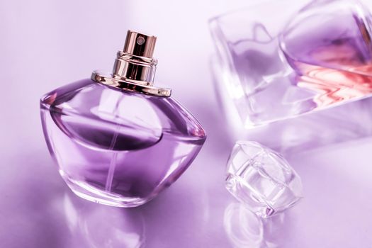 Perfumery, spa and branding concept - Purple perfume bottle on glossy background, sweet floral scent, glamour fragrance and eau de parfum as holiday gift and luxury beauty cosmetics brand design