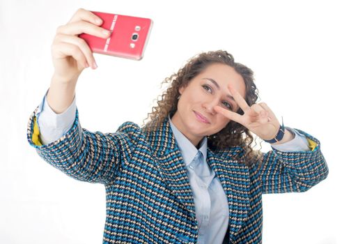 Close up portrait of a cute lovely woman taking selfie and showing peace sign with fingers over white background