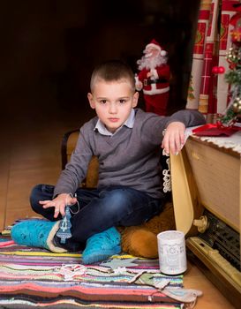 boy in the interior of the house decorated for the new year and christmas