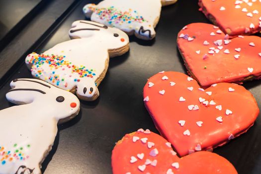 cookies in the form of rabbits and hearts on the shop window. Gingerbread cookies in the form of a rabbit, hearts, covered with white icing-sugar. High quality photo