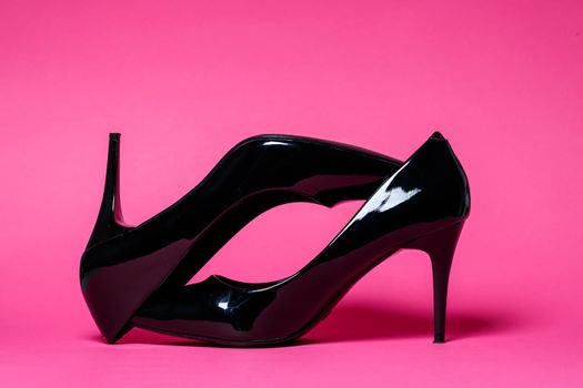 Black patent leather pumps on a colored background