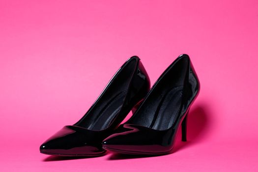 Black patent leather pumps on a colored background