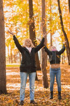 Grandmother with granddaughter in autumn park. Generations and family concept