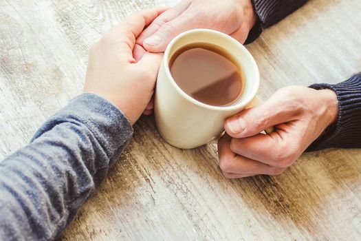 Tea in hand. The lovers are together. Selective focus. Drink.