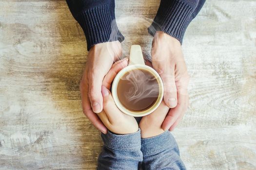 Tea in hand. The lovers are together. Selective focus. Drink.