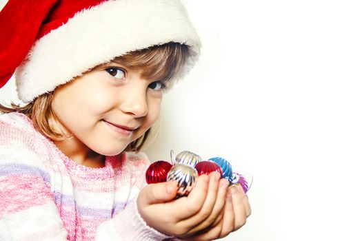 Child holds a Christmas decor and gifts on a white background. Selective focus. Happy.