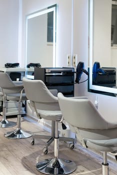 Workplace for haircut in barbershop, with backlit mirror. stylish chairs