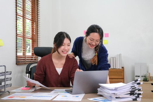 Two young asia business woman working together in office space.