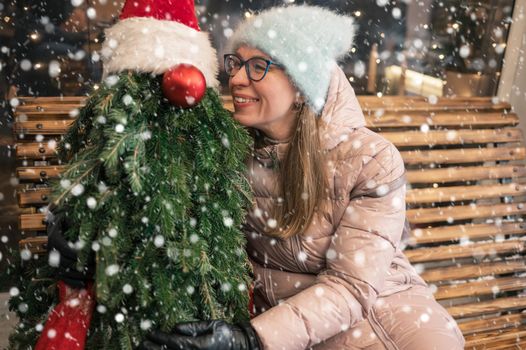 Pretty woman with fir tree decorated mannequin. Xmas holidays, New Year or Christmas concept