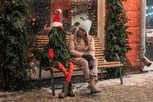 Pretty woman with fir tree decorated mannequin. Xmas holidays, New Year or Christmas concept