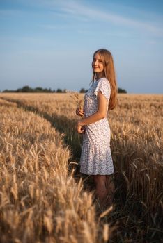 Portrait of a rural girl with bouquet of spikelets