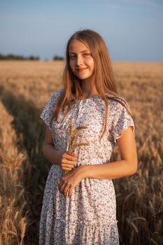Girl in white dress in the field of rye