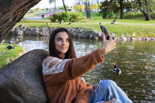 A girl on the shore of the lake makes a sephi