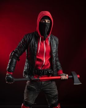 the man in a Balaclava and hoodie with an axe the image of a Protestant