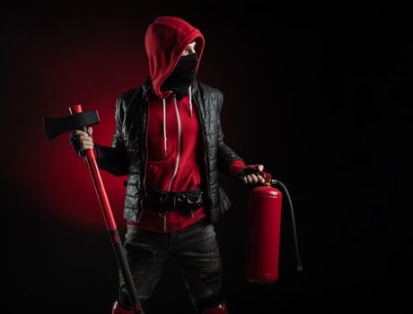 the a man in a Balaclava and hoodie with an axe and a fire extinguisher the image of a Protestant