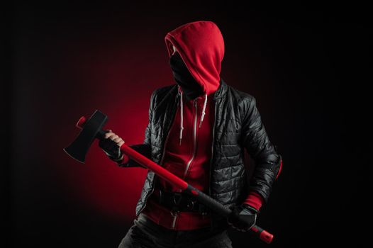 the man in a Balaclava and hoodie with an axe the image of a Protestant