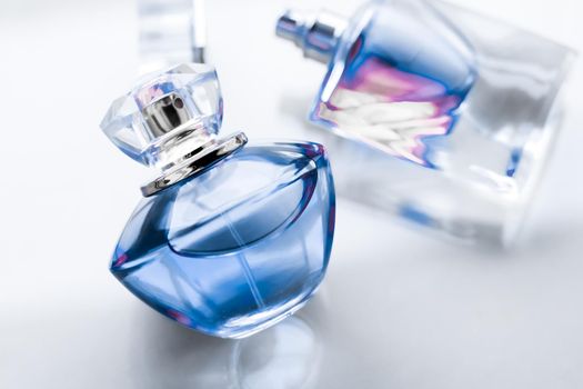 Perfumery, spa and branding concept - Blue perfume bottle on glossy background, sweet floral scent, glamour fragrance and eau de parfum as holiday gift and luxury beauty cosmetics brand design