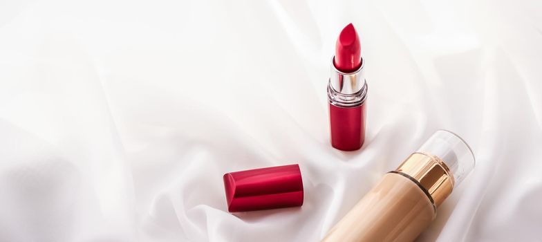 Cosmetic branding, glamour and skincare concept - Beige tonal cream bottle make-up fluid foundation base and red lipstick on silk background, cosmetics products as luxury beauty brand holiday design