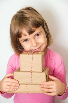 Child holds a Christmas decor and gifts on a white background. Selective focus. Happy.