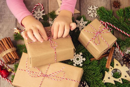 Child holds a Christmas decor and gifts on a white background. Selective focus. Happy.