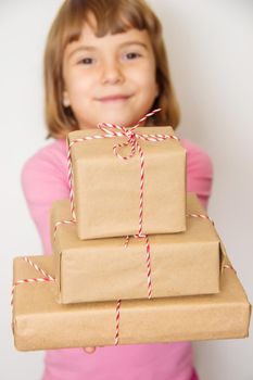 Child holds a Christmas decor and gifts on a white background. Selective focus. Happy.