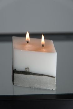 white candle on a concrete base.