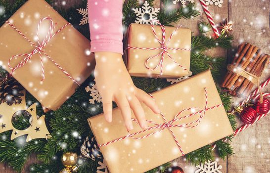 Child holds a Christmas decor and gifts on a white background. Selective focus. Happy.