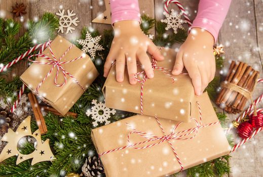 Child holds a Christmas decor and gifts on a white background. Selective focus. Happy.